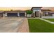 Charming single-story home featuring a well-manicured lawn, three-car garage, and neutral-toned facade with decorative stone accents at 4706 E Des Moines St, Mesa, AZ 85205