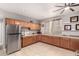 Well-lit kitchen featuring ample wood cabinetry, tile flooring, stainless steel refrigerator, and neutral countertops at 4706 E Des Moines St, Mesa, AZ 85205