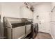 Bright laundry room with a stainless steel wash tub, upper cabinets, and modern gray washer and dryer at 4706 E Des Moines St, Mesa, AZ 85205