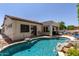Beautiful backyard oasis featuring a swimming pool with rock accents and a covered patio with lounge furniture at 4706 E Des Moines St, Mesa, AZ 85205