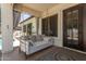Cozy covered porch with a swing bed adorned with pillows, offering a relaxing outdoor seating area at 4706 E Des Moines St, Mesa, AZ 85205