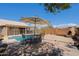 Inviting backyard featuring a pool, fireplace, and outdoor dining area with a shade umbrella at 5049 E Duane Ln, Cave Creek, AZ 85331