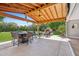Outdoor space under a wooden patio cover featuring an outdoor fireplace, patio furniture, and outdoor grill at 5339 E Osborn Rd, Phoenix, AZ 85018