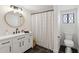 Bathroom featuring updated vanity with a round mirror and black hardware, plus patterned shower curtain at 5339 E Osborn Rd, Phoenix, AZ 85018
