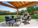Inviting covered patio with fireplace, blue furniture, and lush green lawn is perfect for entertaining at 5339 E Osborn Rd, Phoenix, AZ 85018