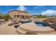 Aerial view of a backyard oasis with pool, spa, covered patio, lush landscaping and two-story home at 5510 N 132Nd Dr, Litchfield Park, AZ 85340