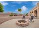 Backyard with seating areas and fire pit with palm trees and water feature at 5510 N 132Nd Dr, Litchfield Park, AZ 85340