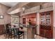 Home bar area with counter seating, granite countertops, and custom cabinetry for entertaining guests at 5510 N 132Nd Dr, Litchfield Park, AZ 85340