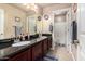Bathroom featuring a double vanity with granite counters, undermount sinks, and cherry-stained wood cabinets at 5510 N 132Nd Dr, Litchfield Park, AZ 85340