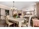 Formal dining area with a decorative chandelier, ornate chairs, and elegant table setting at 5510 N 132Nd Dr, Litchfield Park, AZ 85340