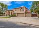 Lovely home exterior with a well-maintained lawn, mature trees, and a spacious three-car garage with plenty of parking space at 5510 N 132Nd Dr, Litchfield Park, AZ 85340