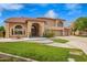 Inviting home exterior with lush green lawn, mature trees, and a circular driveway leading to a spacious three-car garage at 5510 N 132Nd Dr, Litchfield Park, AZ 85340