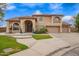 Stunning two-story home with a manicured lawn and a three-car garage, showcasing a grand entrance and desert landscaping at 5510 N 132Nd Dr, Litchfield Park, AZ 85340