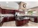 Well-appointed kitchen with a central island, stainless steel appliances, and dark wood cabinets at 5510 N 132Nd Dr, Litchfield Park, AZ 85340
