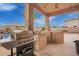 Covered patio with outdoor kitchen and BBQ, perfect for entertaining near the pool at 5510 N 132Nd Dr, Litchfield Park, AZ 85340