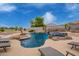 Gorgeous pool and spa, rock waterfall feature, lush landscaping, and lounge chairs at 5510 N 132Nd Dr, Litchfield Park, AZ 85340