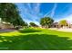 Lush green common area with mature trees, verdant lawn, and walking paths at 5830 E Mckellips Rd # 2, Mesa, AZ 85215