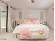 Bedroom with comfy bed, pink accents, and sliding glass door to backyard at 5913 E Thomas Rd, Scottsdale, AZ 85251