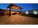Nighttime backyard view featuring a gazebo with string lights and comfortable seating, creating a relaxing atmosphere at 6117 S Adelle --, Mesa, AZ 85212