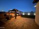 Inviting backyard at dusk, showcasing a cozy gazebo and well-lit artificial turf, perfect for evening relaxation at 6117 S Adelle --, Mesa, AZ 85212