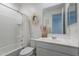 Well-lit bathroom showcasing a shower-tub combo and a modern vanity with a decorative wreath at 6117 S Adelle --, Mesa, AZ 85212