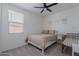 Bright bedroom featuring a ceiling fan, window with blinds, and a cozy bed with neutral-toned bedding at 6117 S Adelle --, Mesa, AZ 85212