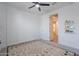 Minimal bedroom featuring paneled wall, view into the hallway, rug and a ceiling fan at 6117 S Adelle --, Mesa, AZ 85212