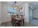 Cozy dining area with a wooden table, chairs, stylish lighting, and a view to the backyard at 6117 S Adelle --, Mesa, AZ 85212