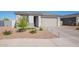 Inviting single-story home boasts desert landscaping, a paved driveway, and a two-car garage, enhancing its curb appeal at 6117 S Adelle --, Mesa, AZ 85212