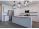 Bright kitchen features stainless steel appliances, white cabinetry, granite countertops, and an island with modern pendant lighting at 6117 S Adelle --, Mesa, AZ 85212