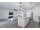 Spacious open concept featuring kitchen and living room, with island, stainless appliances, and modern lighting at 6117 S Adelle --, Mesa, AZ 85212