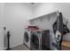 Functional laundry room with washer, dryer, folding shelf, and cleaning supplies at 6117 S Adelle --, Mesa, AZ 85212