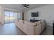 Bright living room featuring a large sofa, a TV, and sliding glass doors to an outdoor area at 6117 S Adelle --, Mesa, AZ 85212