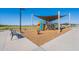 A playground features a shade canopy, play structures, spring riders and nearby park benches at 6117 S Adelle --, Mesa, AZ 85212