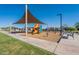 A park's playground featuring play structures, spring riders, benches, and a covered picnic area at 6117 S Adelle --, Mesa, AZ 85212