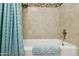 Bathroom featuring a bathtub and shower with tiled walls and a decorative accent strip at 7042 N 13Th St, Phoenix, AZ 85020
