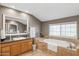 Bright bathroom featuring a soaking tub, granite counters, and neutral color palette at 7042 N 13Th St, Phoenix, AZ 85020