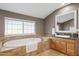 Bathroom boasts an inviting soaking tub, large window, and granite countertops at 7042 N 13Th St, Phoenix, AZ 85020