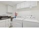 Laundry area featuring a washer, dryer, overhead cabinets and adjacent folding area at 7042 N 13Th St, Phoenix, AZ 85020