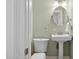 Powder room featuring a pedestal sink, oval mirror, toilet and light green paint at 7042 N 13Th St, Phoenix, AZ 85020
