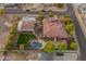 Aerial view showcasing the home's backyard oasis with a pool, lush lawn, and meticulous landscaping at 7425 W Caro Rd, Glendale, AZ 85308