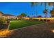 Lush backyard with green lawn, and ambient string lights creating a welcoming outdoor space at 7425 W Caro Rd, Glendale, AZ 85308
