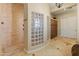 Elegant bathroom featuring tile floors, a glass block privacy wall, and a tiled shower with a bench seat at 7425 W Caro Rd, Glendale, AZ 85308
