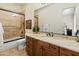 Bathroom with double sink vanity with marble countertop and tiled shower with glass doors at 7425 W Caro Rd, Glendale, AZ 85308
