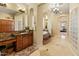 Luxurious bathroom featuring a vanity with wood cabinets, tiled floors, and a tub with steps at 7425 W Caro Rd, Glendale, AZ 85308