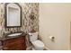 Elegant half bathroom featuring decorative tile wall and ornate mirror above the vanity at 7425 W Caro Rd, Glendale, AZ 85308