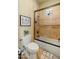 Bathroom with a shower with a glass door, neutral tile, and a plant sitting on the toilet at 7425 W Caro Rd, Glendale, AZ 85308