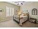 Bright bedroom featuring light paint, shuttered windows, and a decorative black iron bedframe at 7425 W Caro Rd, Glendale, AZ 85308