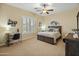 Comfortable bedroom with neutral colors, desk, and light coming in through shuttered window at 7425 W Caro Rd, Glendale, AZ 85308