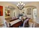 Bright dining area with an elegant chandelier and arched doorways offers a stylish space for entertaining at 7425 W Caro Rd, Glendale, AZ 85308